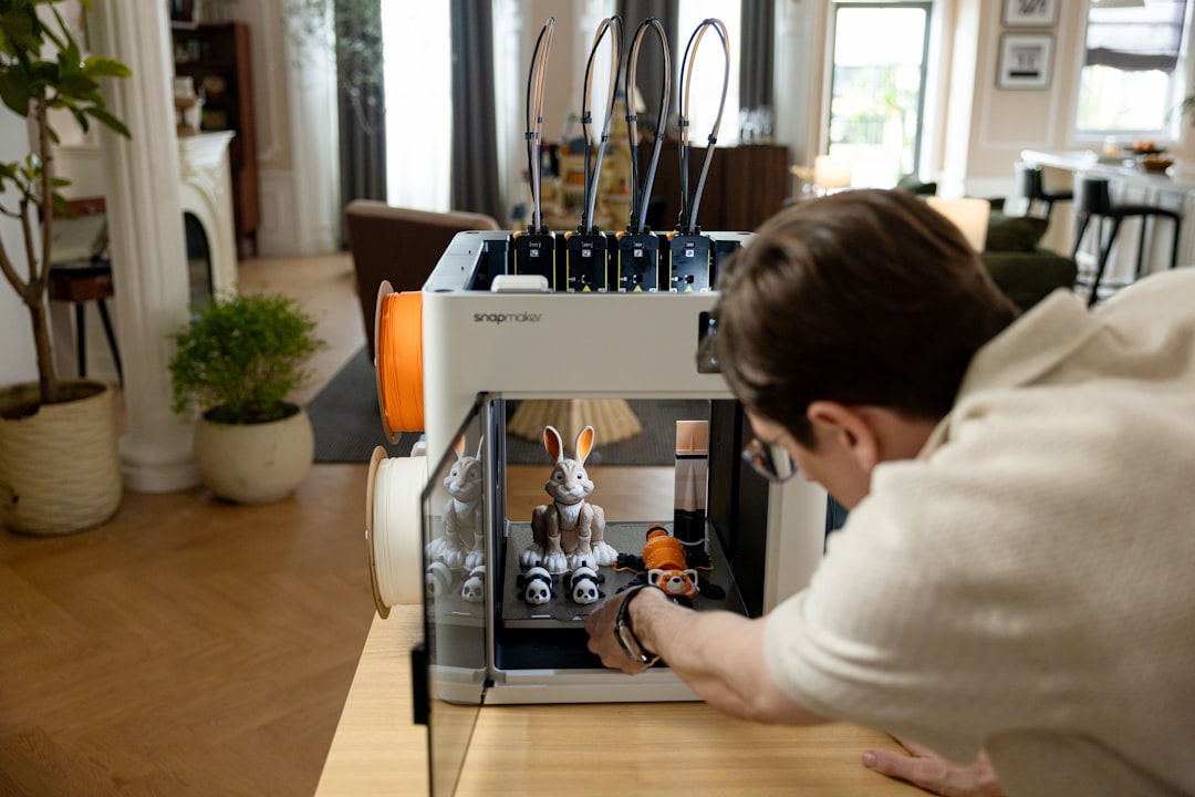 At home, a user removes a finished figurine from the enclosed Snapmaker U1 multicolor 3D printer with simple touch control and safe handling.