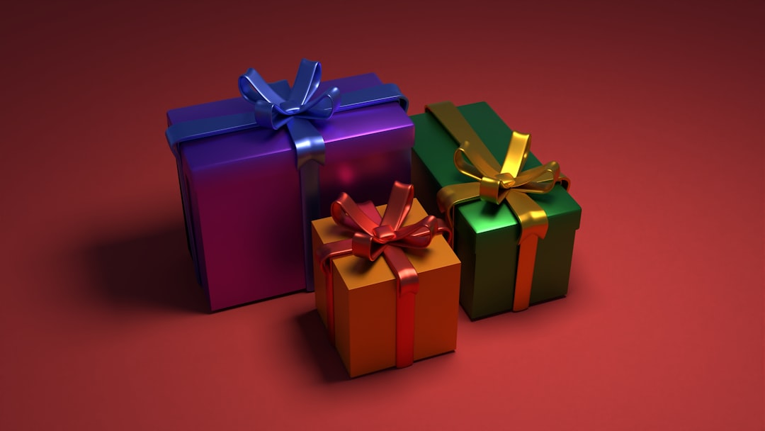 three-colorful-gift-boxes-with-bows-on-a-red-background-vkdx3z4hclw